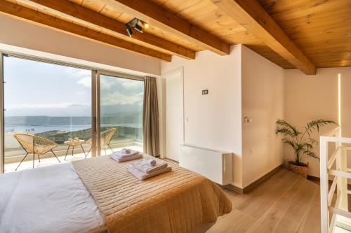 a bedroom with a bed and a large window at Fantasea Villas, villa Lumi in Stérnai