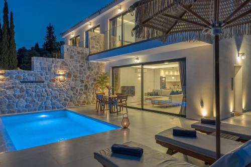 a villa with a swimming pool in front of a house at Jasmina Villas in Agios Nikolaos