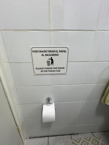 a toilet paper sign on the wall of a bathroom at Cabañas Campestres Inés in Chillán
