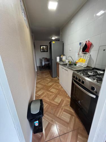 a kitchen with a stove and a refrigerator at Cabañas Campestres Inés in Chillán