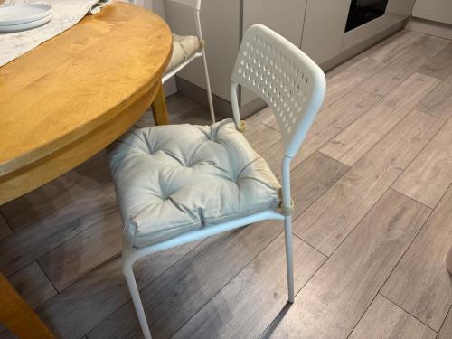 a white chair with a pillow on it next to a table at Sowerby Apartment in Sowerby Bridge