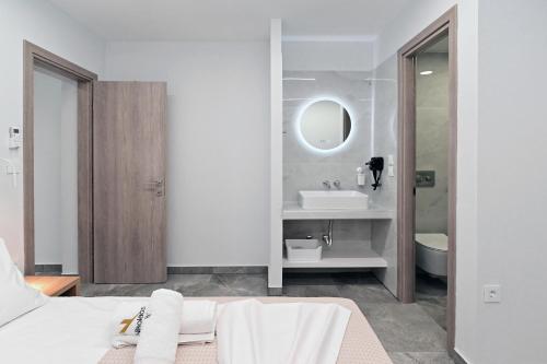 a white bathroom with a bed and a sink at Agios Nikolaos Villas in Ayios Nikolaos Sithonia