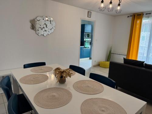 a dining room with a white table and chairs at Appartement tout confort avec parking privé in Montréjeau