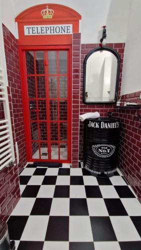 a red phone booth with a black and white checkered floor at Le Segrete del pozzo 80's Room in Capurso