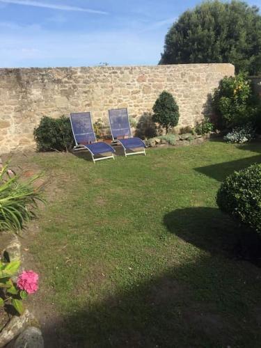 three blue chairs sitting in the grass in a yard at 36 rue Saint Nicolas Barfleur jardin clos 30m Port in Barfleur
