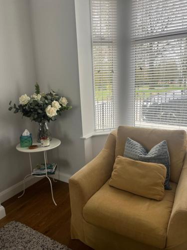 a living room with a couch and a vase of flowers at Grange House in Omagh