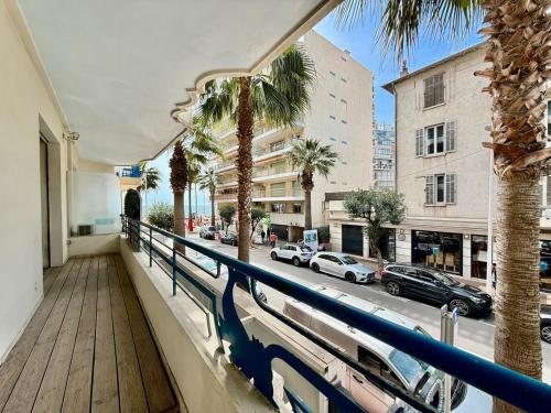 d'un balcon avec des palmiers et une rue de la ville. dans l'établissement Hypercentre - Vue Mer - Plage 50m, à Antibes