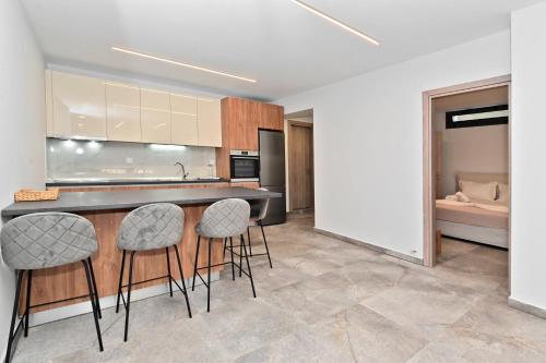 a kitchen with a counter and stools in a room at Agios Nikolaos Villas in Ayios Nikolaos Sithonia