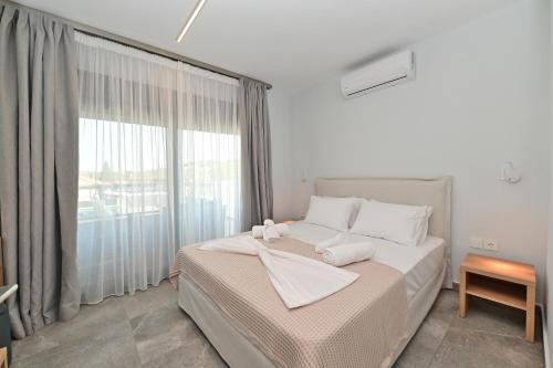 a bedroom with a bed and a large window at Agios Nikolaos Villas in Ayios Nikolaos Sithonia