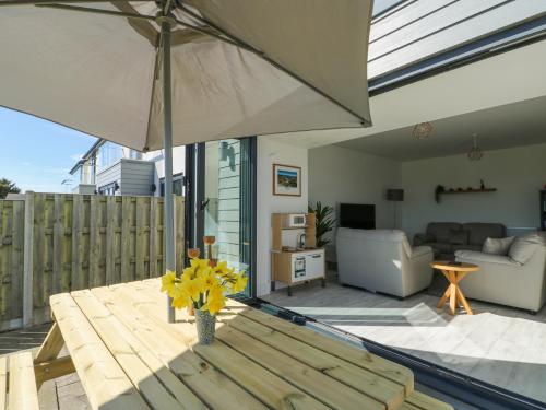 a living room with a table and an umbrella at 6 Gwel Yr Wyddfa in Rhosneigr