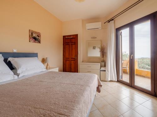 a bedroom with a bed and a sliding glass door at Alexandra House in Kríni