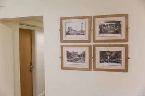 a group of framed photographs on a wall at The Resolution Hotel in Whitby