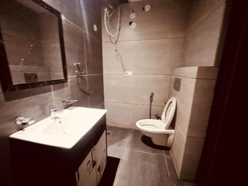 a bathroom with a sink and a toilet and a mirror at Patang Guest House in Nainital