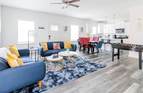a living room with blue couches and a ping pong table at Chic Home 9 min to Uptown Hot Tub & Private Yard in Charlotte