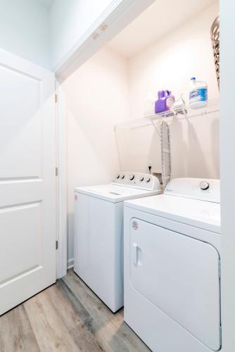 a white laundry room with a washer and dryer at Chic Home 9 min to Uptown Hot Tub & Private Yard in Charlotte