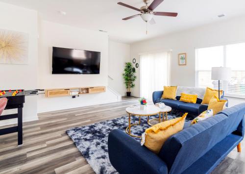 a living room with two blue couches and a tv at Chic Home 9 min to Uptown Hot Tub & Private Yard in Charlotte