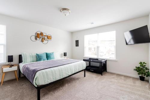 a bedroom with a bed and a flat screen tv at Chic Home 9 min to Uptown Hot Tub & Private Yard in Charlotte