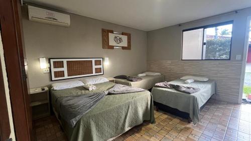 a room with two beds and a window at Sonhos de Penha - Chalés e Aptos in Penha