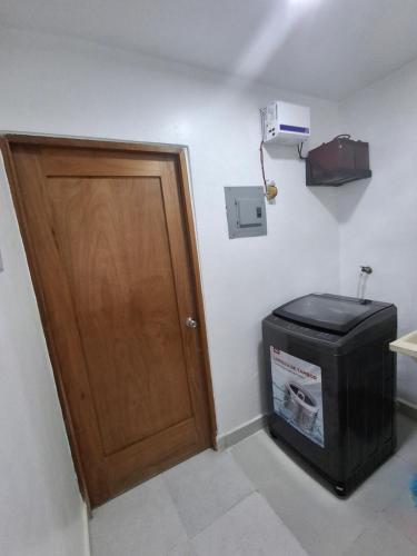 a room with a wooden door and a trash can at Comfortable Apartament in Los Paredones