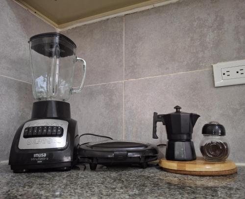 a blender sitting on a counter next to a coffee maker at Comfortable Apartament in Los Paredones