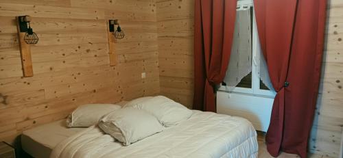 Ce lit se trouve dans une chambre en bois dotée d'une fenêtre. dans l'établissement duplex de charme de 70m2, à Margencel