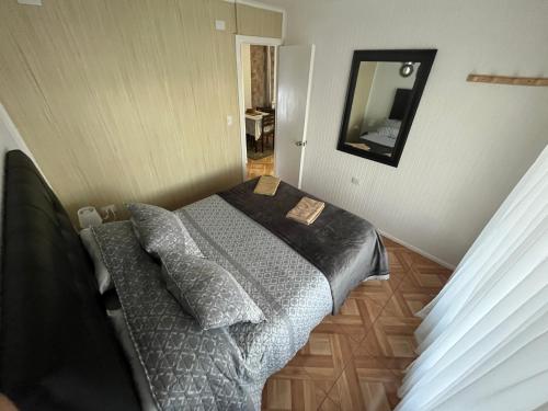 a small bedroom with a bed and a mirror at Cabañas Campestres Inés in Chillán