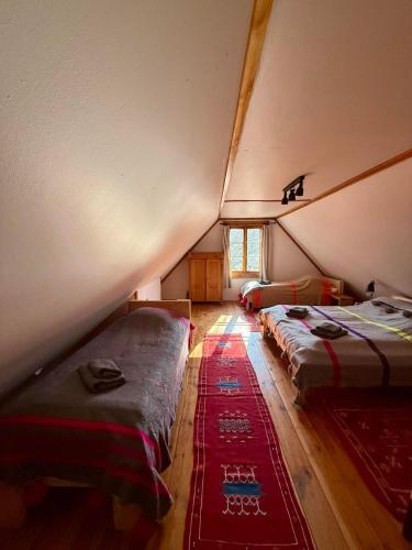 a attic room with two beds and a rug at Cisowe Wzgórze in Rowele
