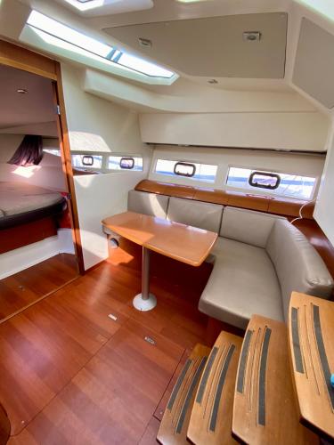 une petite chambre avec une table et des bancs dans un bateau dans l'établissement Une nuit inoubliable sur un bateau Linge et ménage inclus, à La Rochelle