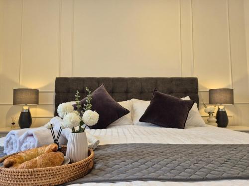 a bed with a basket of bread and a vase of flowers at Cozy Farmhouse mit Terasse - 5min zum Waldweg in Bischofsgrün