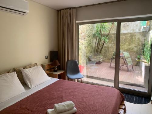 a bedroom with a bed and a sliding glass door at Casa da Nau in Vila do Conde