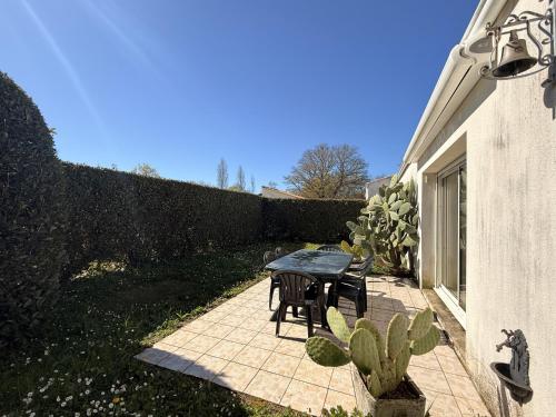 a patio with a table and chairs and a fence at Maison moderne au centre d'Oléron in Dolus d'Oléron