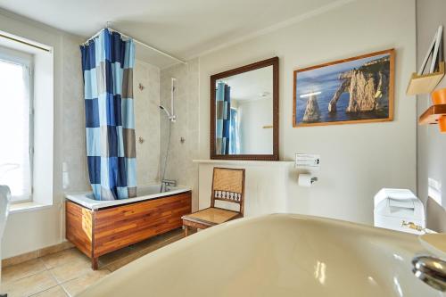 La salle de bains est pourvue d'une baignoire et d'une chaise. dans l'établissement Grand JUNO, à Courseulles-sur-Mer