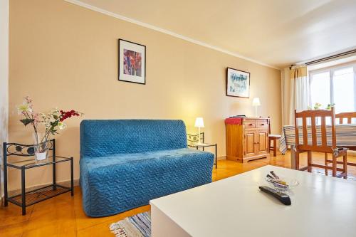 un salon avec une chaise bleue et une table dans l'établissement Grand JUNO, à Courseulles-sur-Mer