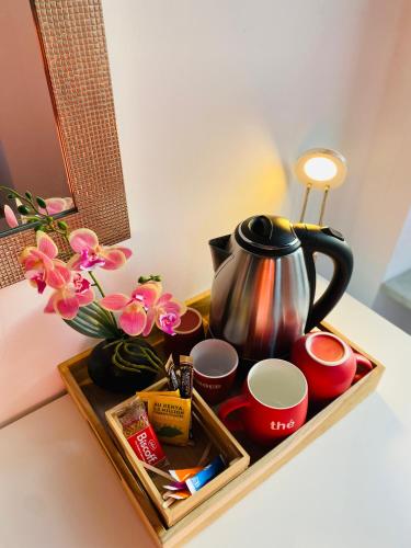 - un plateau/bouilloire avec des tasses et des fleurs dans l'établissement Home SAINT MICHEL, à Pontorson