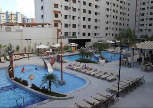 a large pool with a water slide in a resort at Thermas Boulevard Suíte Hotel - Weigly in Caldas Novas