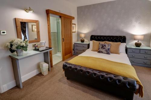 a bedroom with a large bed and a mirror at Ye Olde Cheshire Cheese Inn in Castleton