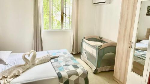 a small bedroom with a crib and a window at Villa Chanel avec piscine proche de la plage in Grand-Baie