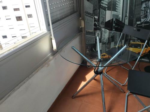 a glass table and a chair next to a window at Lisbon West Space in Lisbon