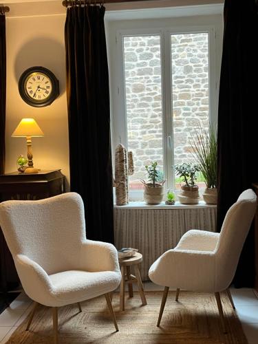 a living room with two chairs and a window at 36 rue Saint Nicolas Barfleur jardin clos 30m Port in Barfleur
