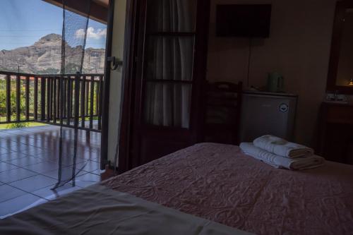 a bedroom with a bed and a balcony with a view at Pineas in Kalabaka