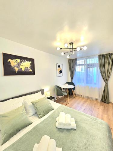 Un dormitorio con una cama grande y una mesa. en City Center Apartment Cluj, en Cluj-Napoca