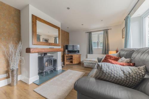 a living room with a couch and a fireplace at Riverside Cottage 6 guests 4 adults max hot tub in Backbarrow