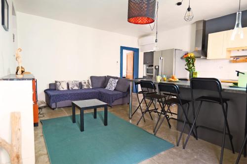 Il comprend une cuisine et un salon avec un canapé bleu. dans l'établissement Appartement Rosset - Welkeys, à Montpellier