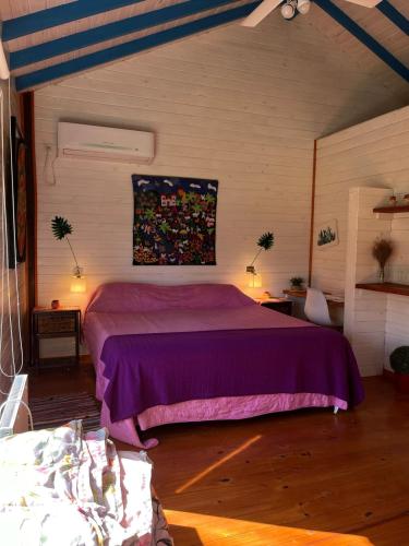 a bedroom with a purple bed in a room at Itaca delta cabañas in Tigre