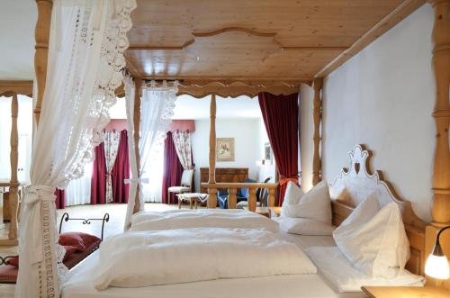 1 dormitorio con 1 cama blanca grande con dosel en Ciasa Anteriol, en San Cassiano