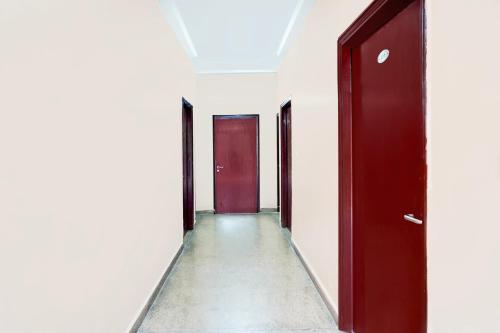 an empty corridor with red doors in an office building at Super Hotel O GMS Road Ballupur Chowk in Dehradun