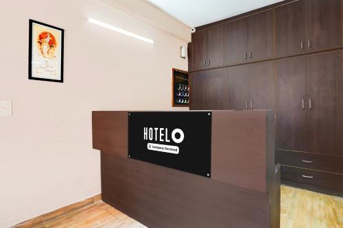a room with a counter and wooden cabinets at Super Hotel O GMS Road Ballupur Chowk in Dehradun