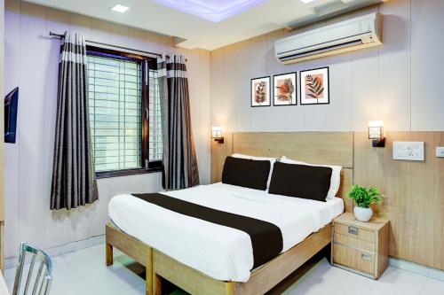 a bedroom with a large bed and a window at Super Hotel O Rohini Sector 24 in New Delhi