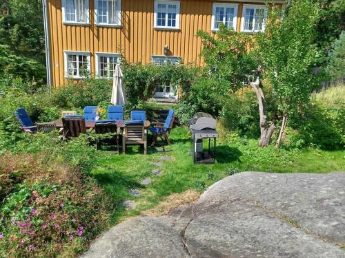 a yard with chairs and a table and an umbrella at Large house with sea arch, beach and jetty in Lillesand