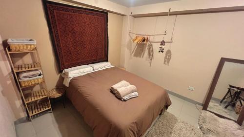 a small bedroom with a bed with a headboard at Cosy flat in the heart of Pisac with rooftop terrace in Pisac